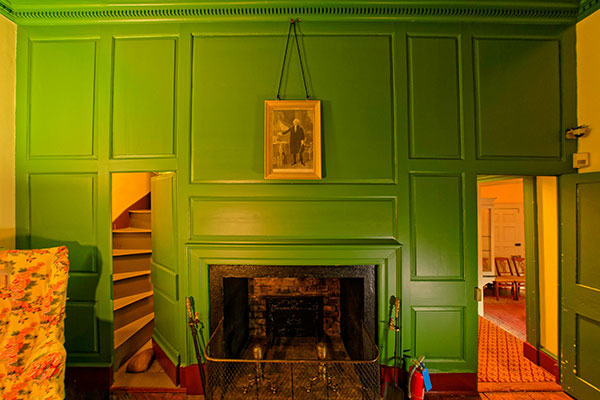a green room with a secret staircase behind a wall panel