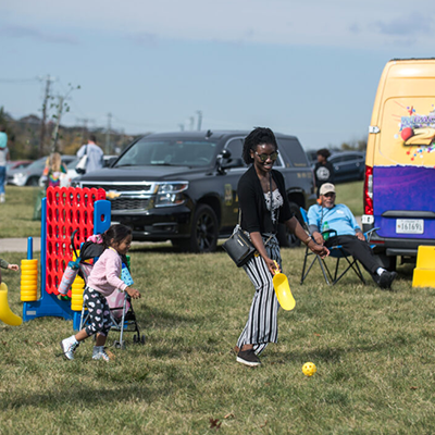 Photo of waterfront Arts festival. Two adults playing a game with a child