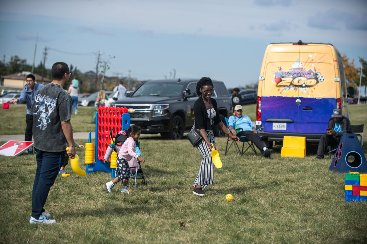 Photo of waterfront Arts festival. Two adults playing a game with a child