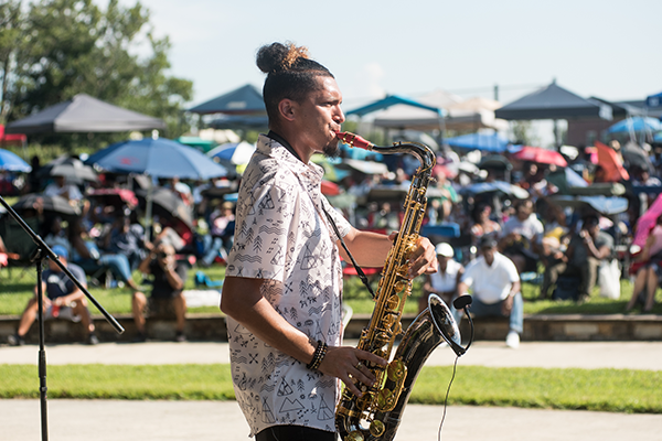 A man playing a saxophone in front of a crowd