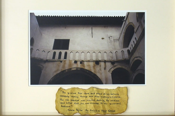 A photo and a description. The description is unreadable, and the image is of an old building with a balcony, and many archways.