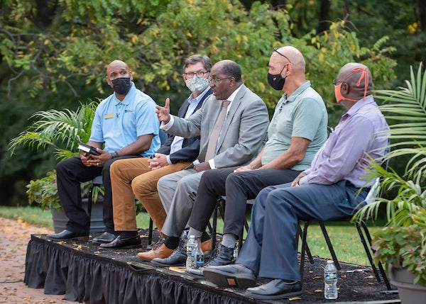 A panel of 5 men sitting in a chair talking