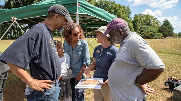 Four adults and one child in a circle having a conversation