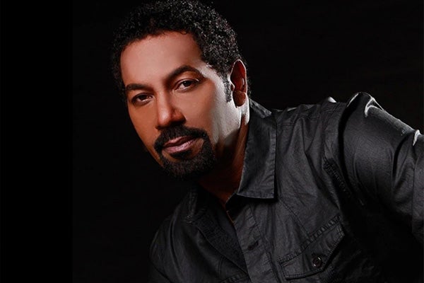 Headshot of a man with a goatee wearing a gray shirt.