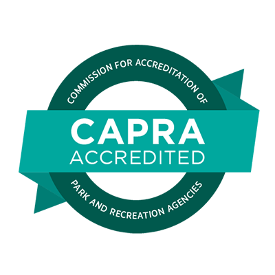 Logo with the words CAPRA ACCREDITED on a banner across a green circle that reads Commission for Accreditation of Park and Recreation Agencies.